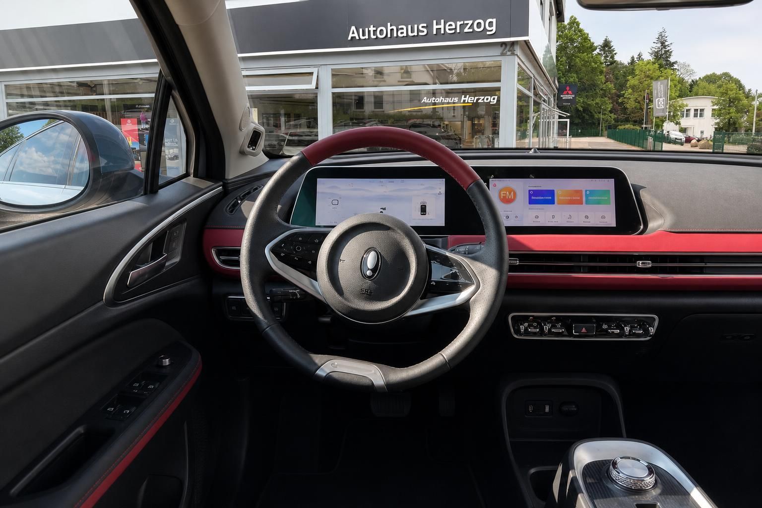 Cockpit mit rotem Lenkrad und Doppelbildschirm im GWM Ora 03