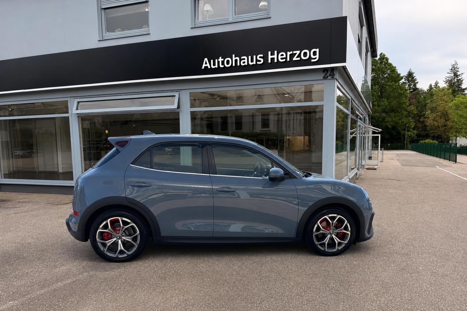 GWM Ora 03 grau Seitenansicht vor Autohaus Herzog