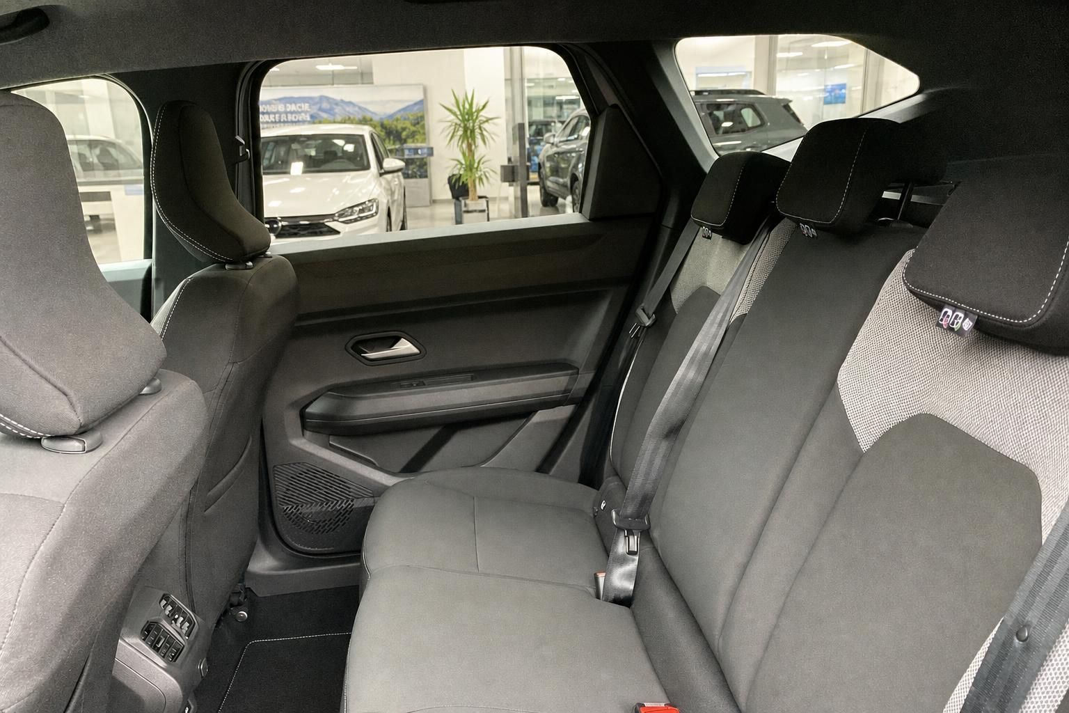 Ruecksitze mit grauer Polsterung und Blick durch Seitenfenster im Autohaus