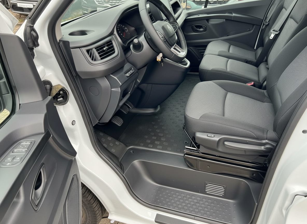 Fahrzeuginnenraum mit grauem Stoffsitz, Lenkrad und schwarzem Gummifußmatten-Set