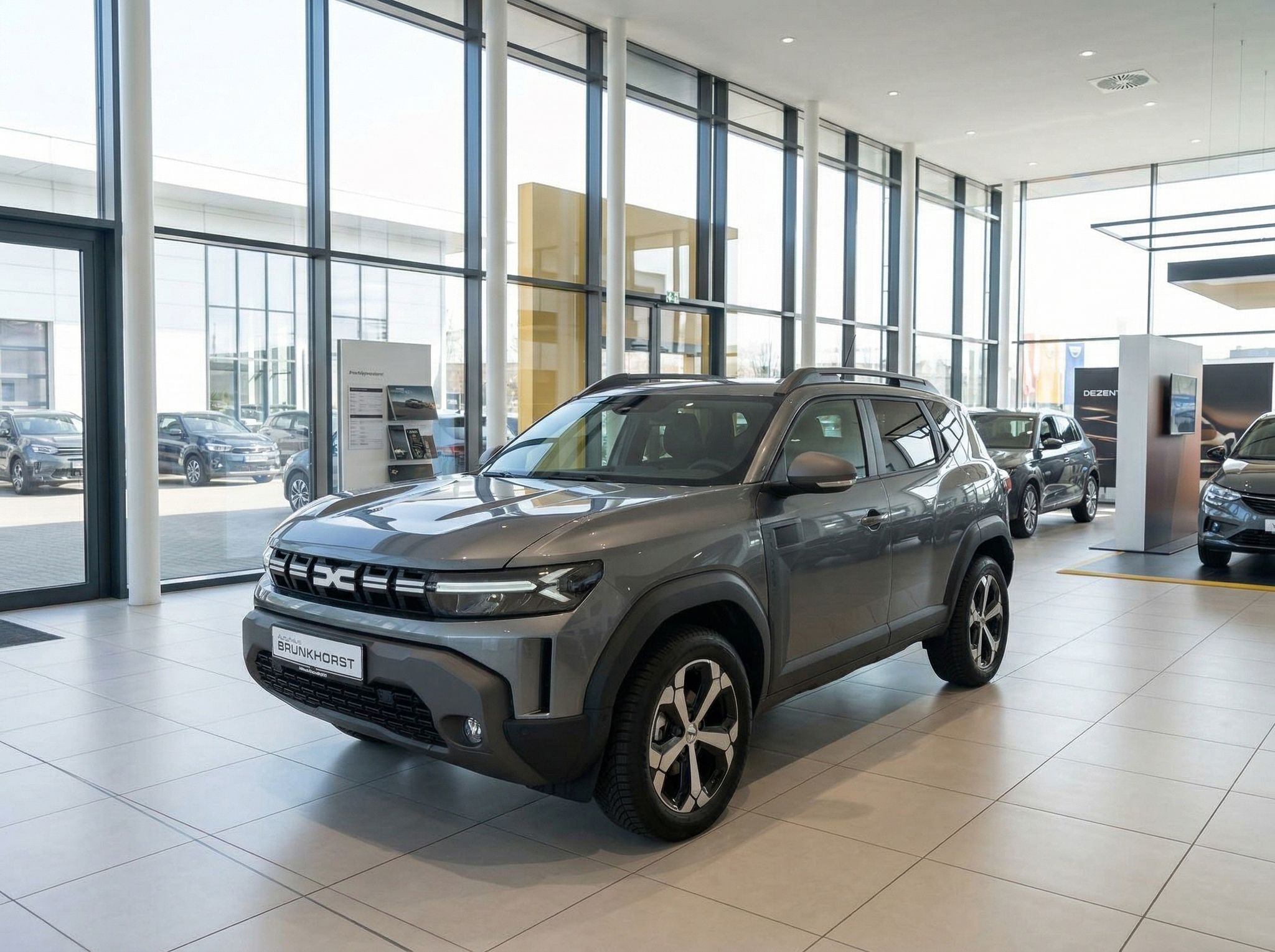 Dacia SUV grau im Autohaus Showroom - Seitenansicht vorne links mit modernem Design