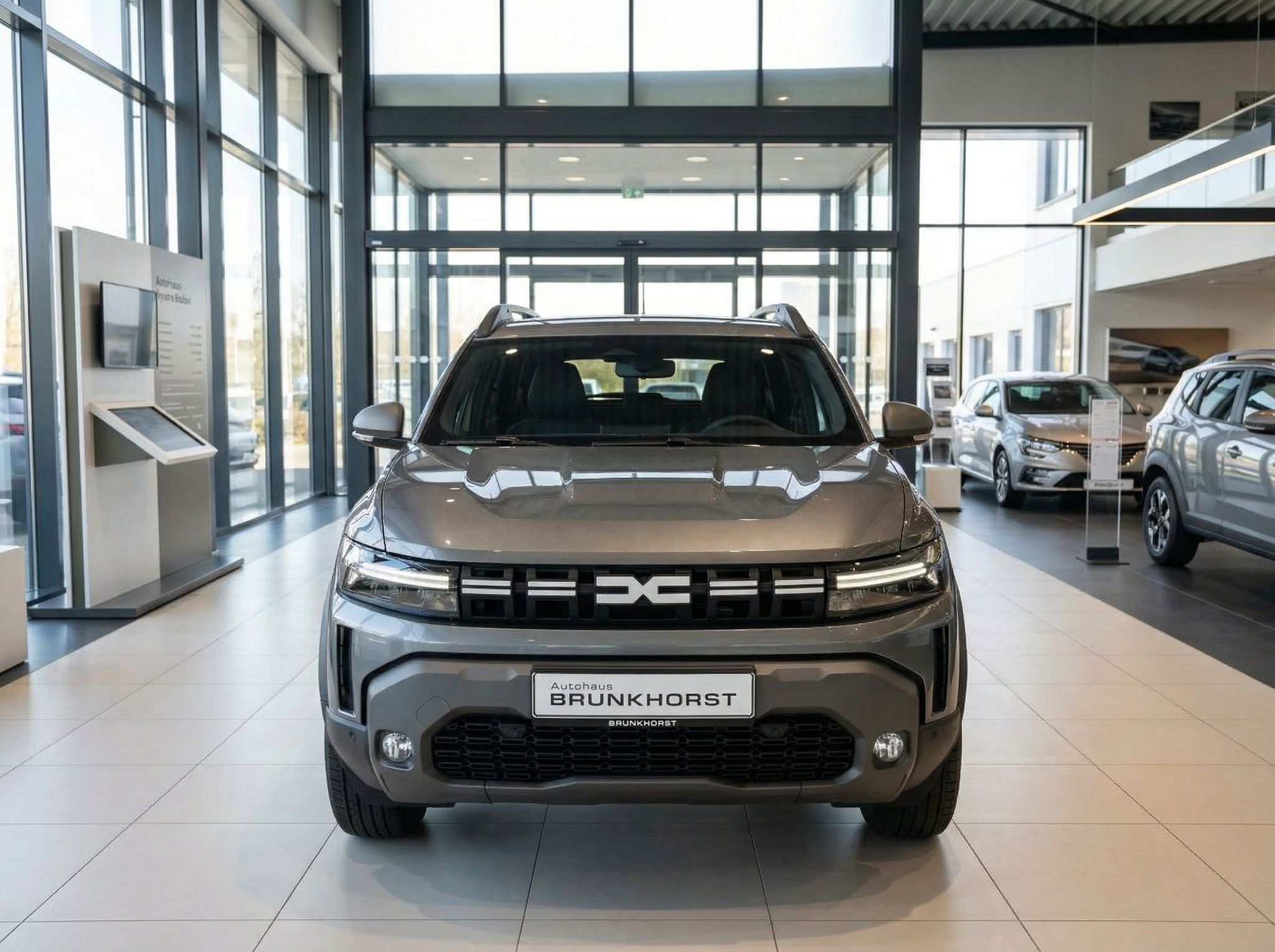 Dacia SUV beige - Frontansicht im Autohaus Showroom mit LED-Scheinwerfern