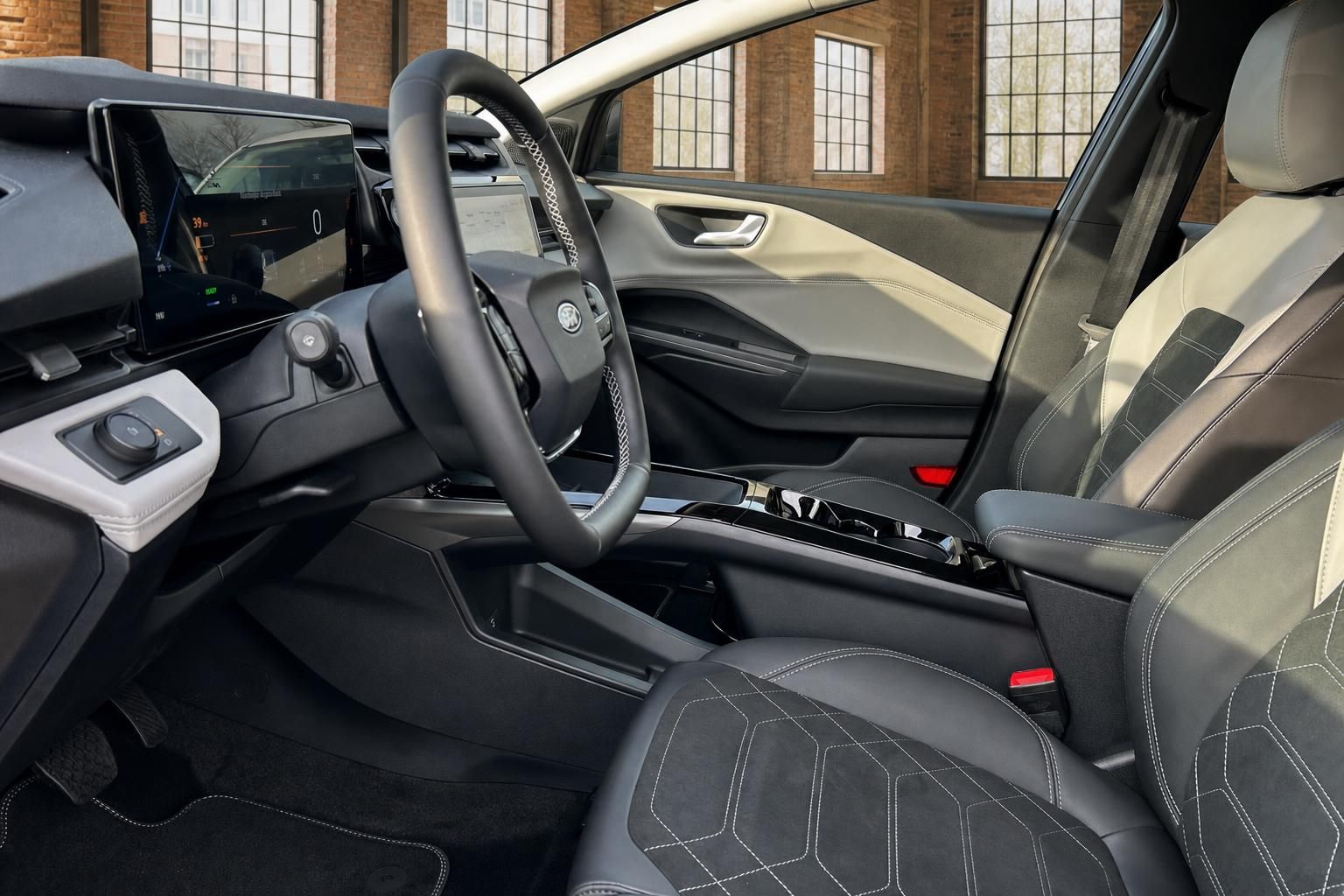 Ford Innenraum Fahrerseite mit Lenkrad, Touchscreen und schwarzen Ledersitzen mit weißer Ziernaht