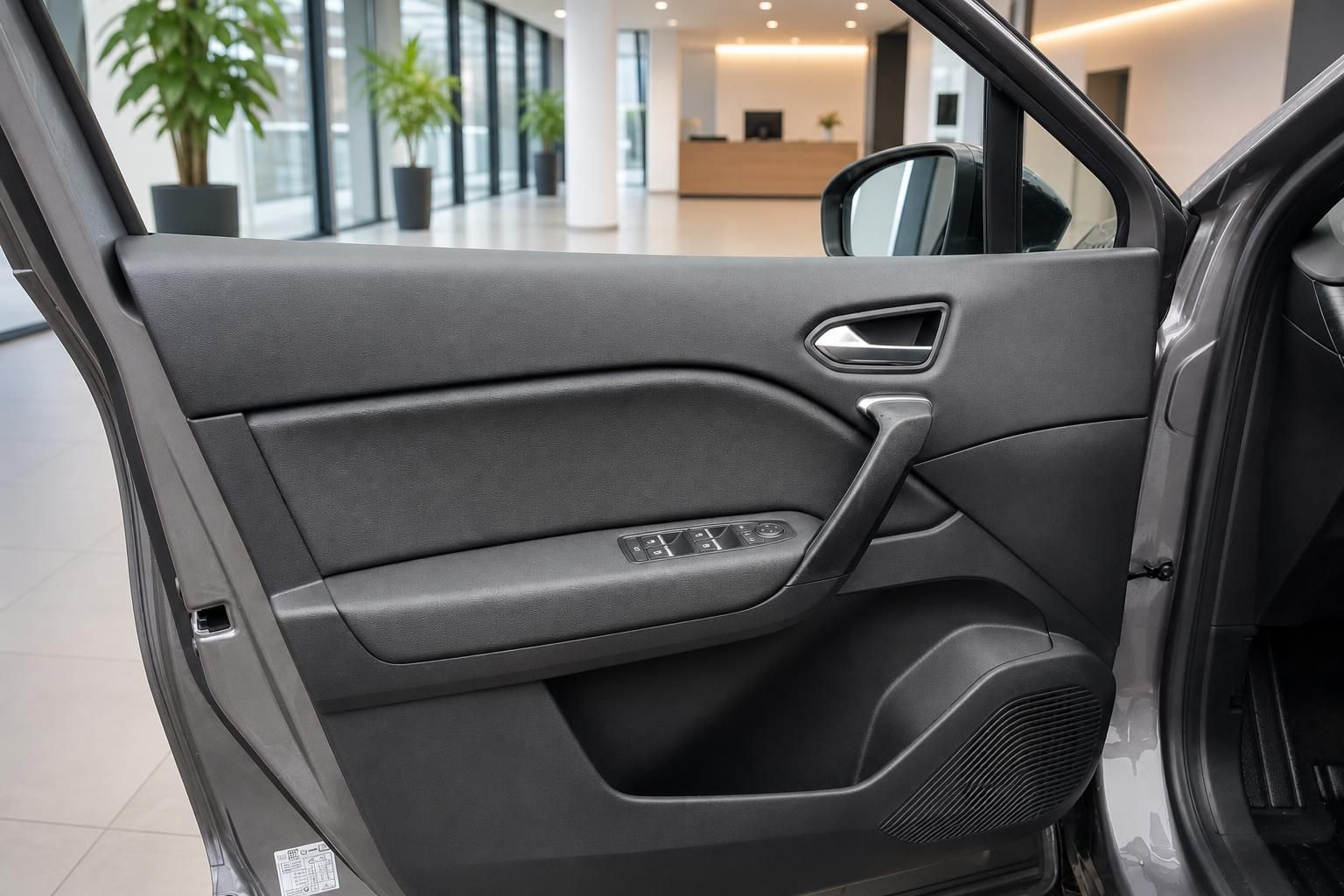 Fahrzeug-Türverkleidung mit Fensterheberschaltern und grauer Innenausstattung