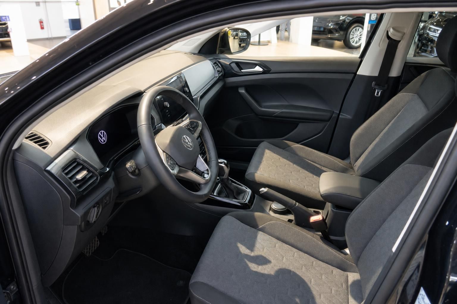 Innenraum eines Volkswagen mit Lenkrad, Armaturenbrett und Fahrersitz im Autohaus