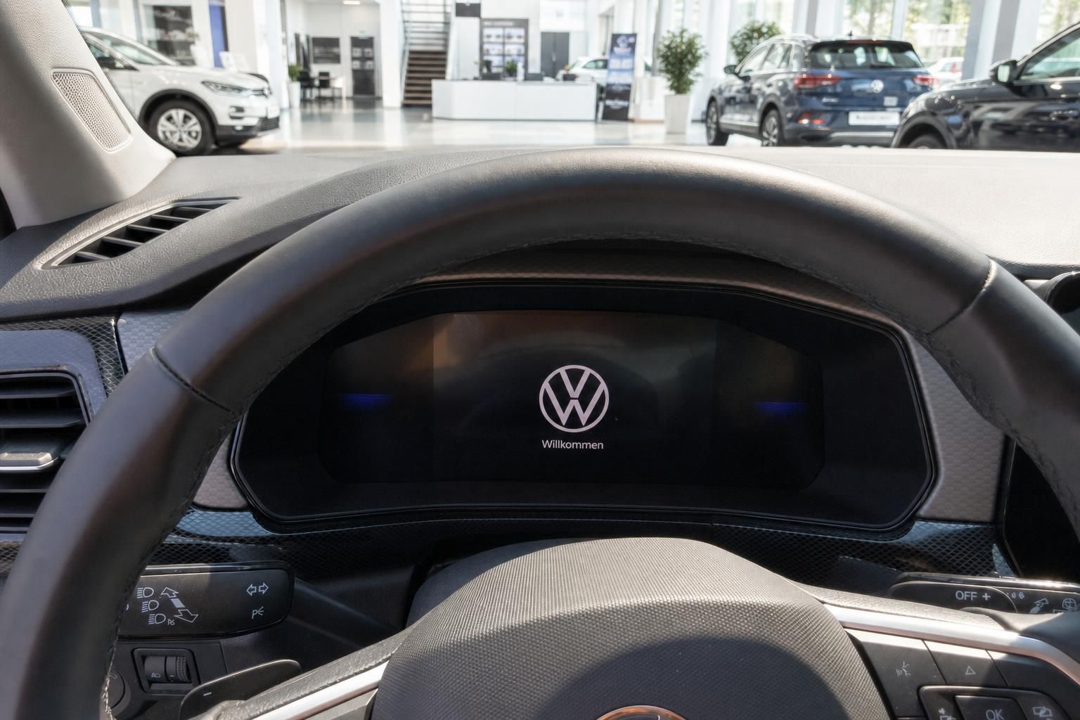 Digitales Cockpit eines Volkswagen mit Willkommen-Anzeige und Lenkradtasten