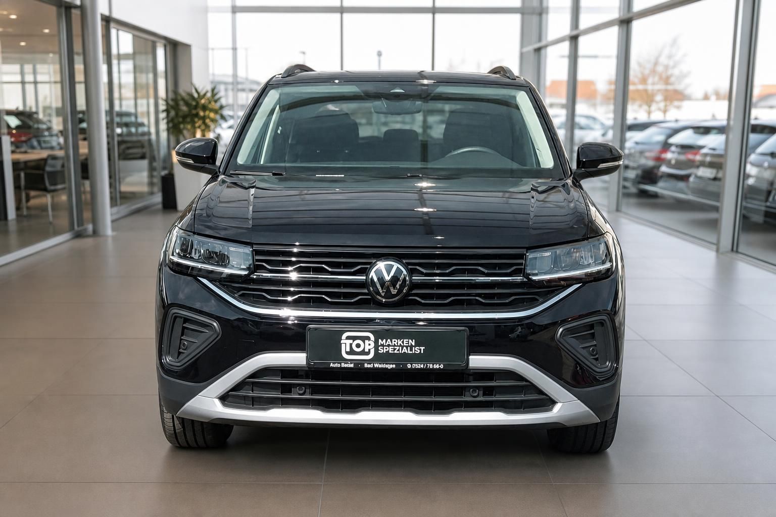 Schwarzer VW SUV Frontansicht gerade im Showroom - Crossover mit charakteristischem VW-Kühlergrill