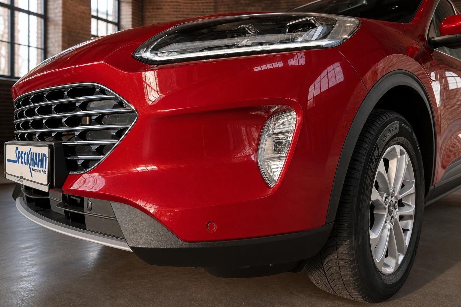 Detailansicht Frontstossstange und Scheinwerfer des roten Ford SUV