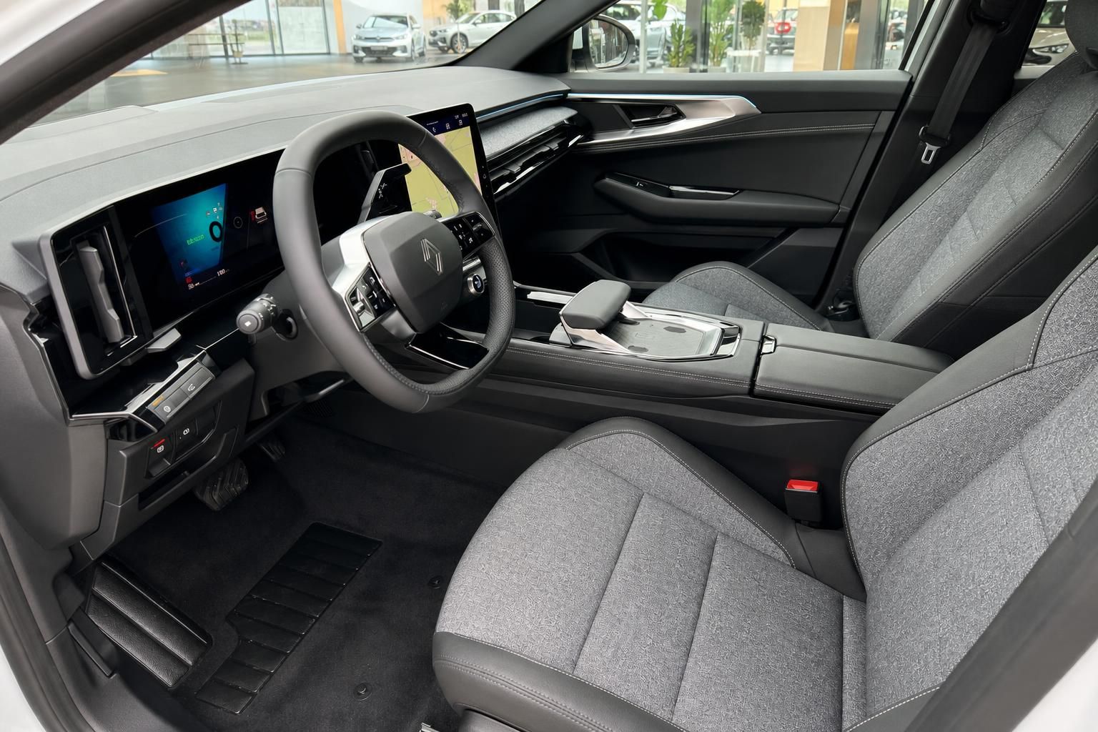 Renault Innenraum mit digitalem Cockpit, Lenkrad und grauen Stoffsitzen - Fahrersicht