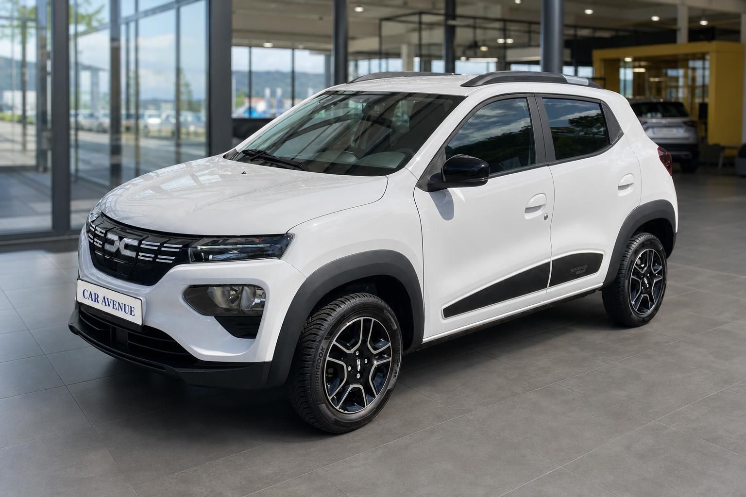 Dacia Spring weiß, Seitenansicht schräg vorne im Showroom