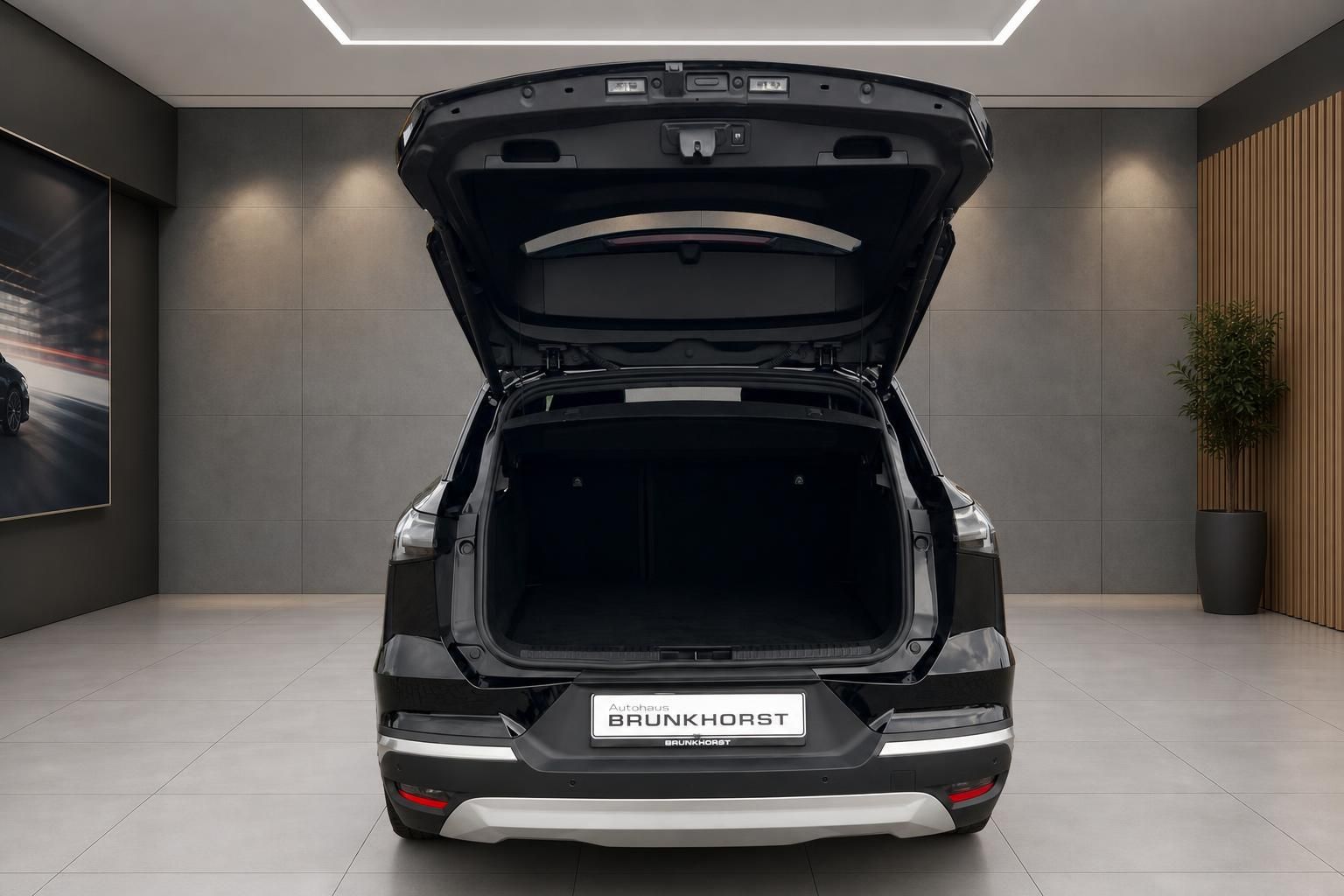 Fahrzeug mit geoeffneter Heckklappe und grossem Kofferraum im Autohaus