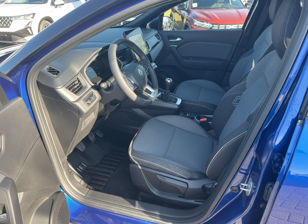 Renault Clio Innenraum Fahrerseite mit schwarzen Sitzen und modernem Cockpit in blauem Fahrzeug