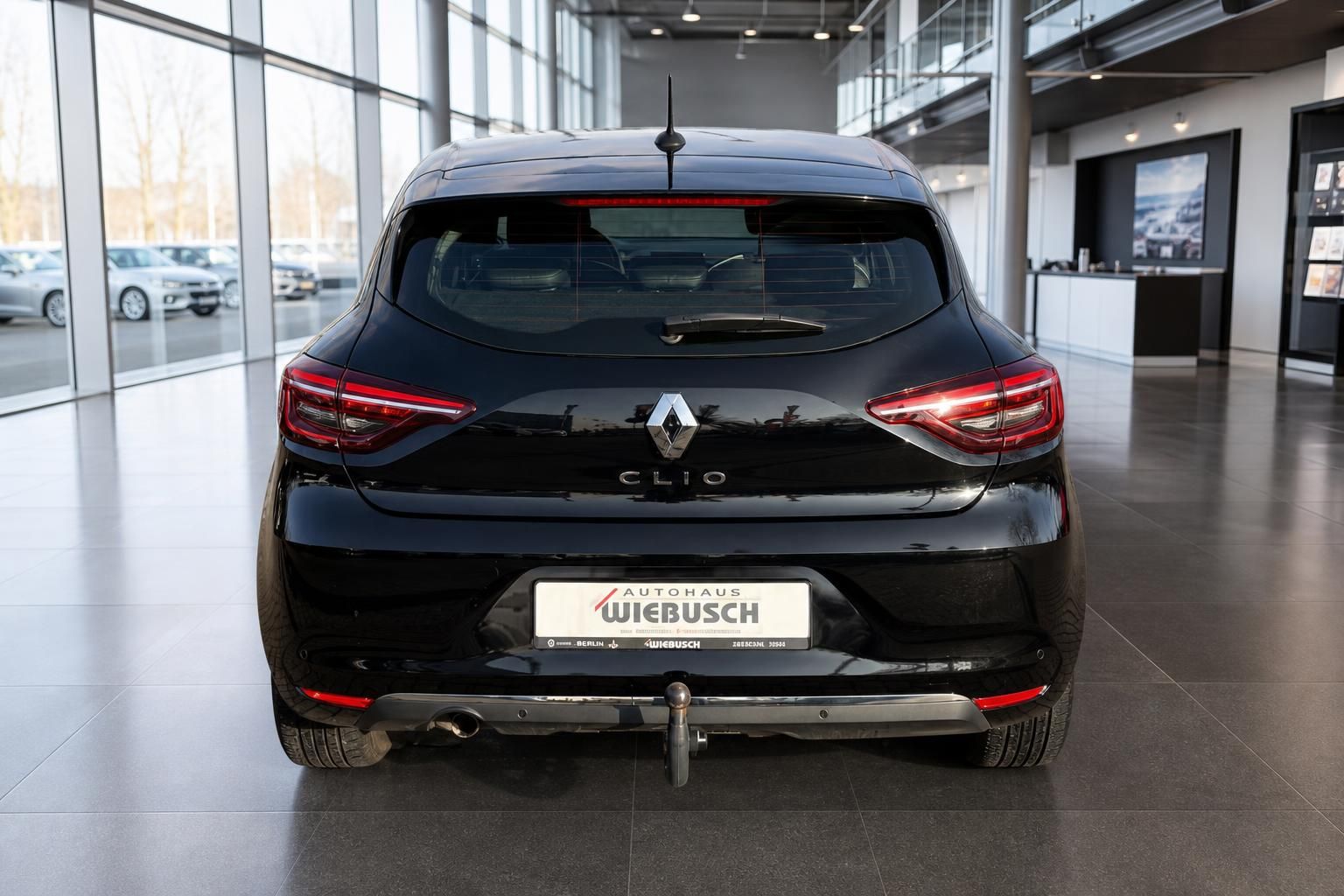 Renault Clio Heckansicht in schwarz mit LED-Rücklichtern im modernen Autohaus-Showroom