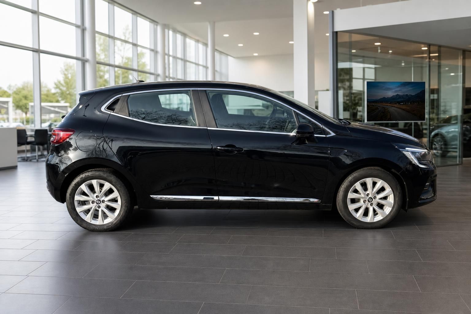 Renault Clio Seitenansicht in schwarz mit eleganten Leichtmetallfelgen im Autohaus