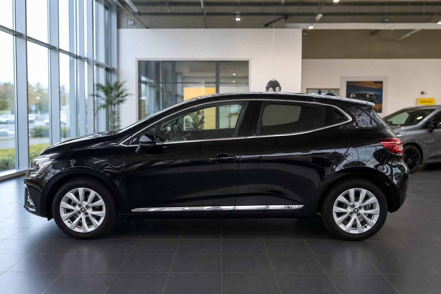 Schwarzer Renault Clio Seitenansicht - Kompaktfahrzeug mit Leichtmetallfelgen im Showroom