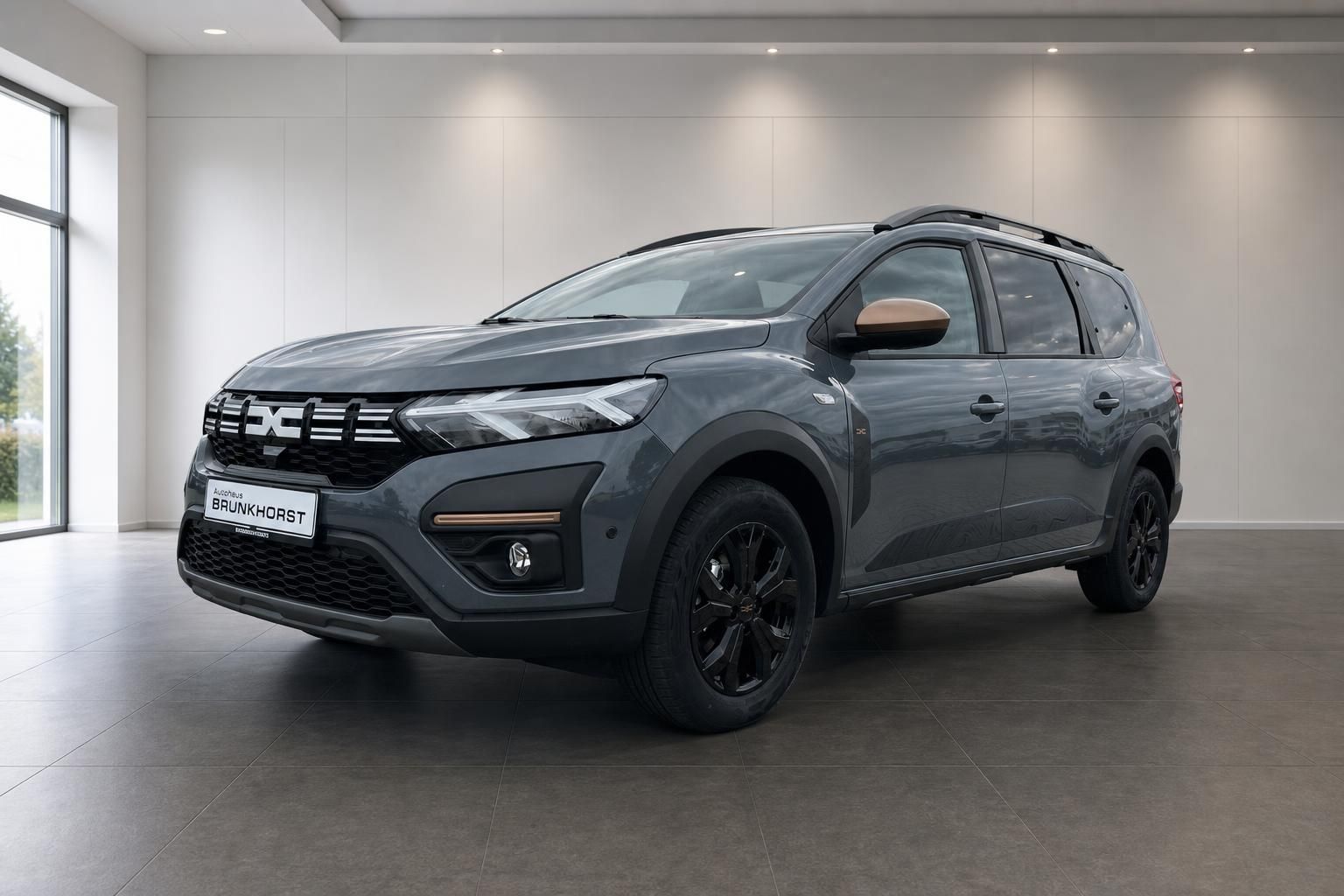 Dacia Jogger Hybrid SUV grau im Autohaus Showroom - Frontansicht mit schwarzen Felgen