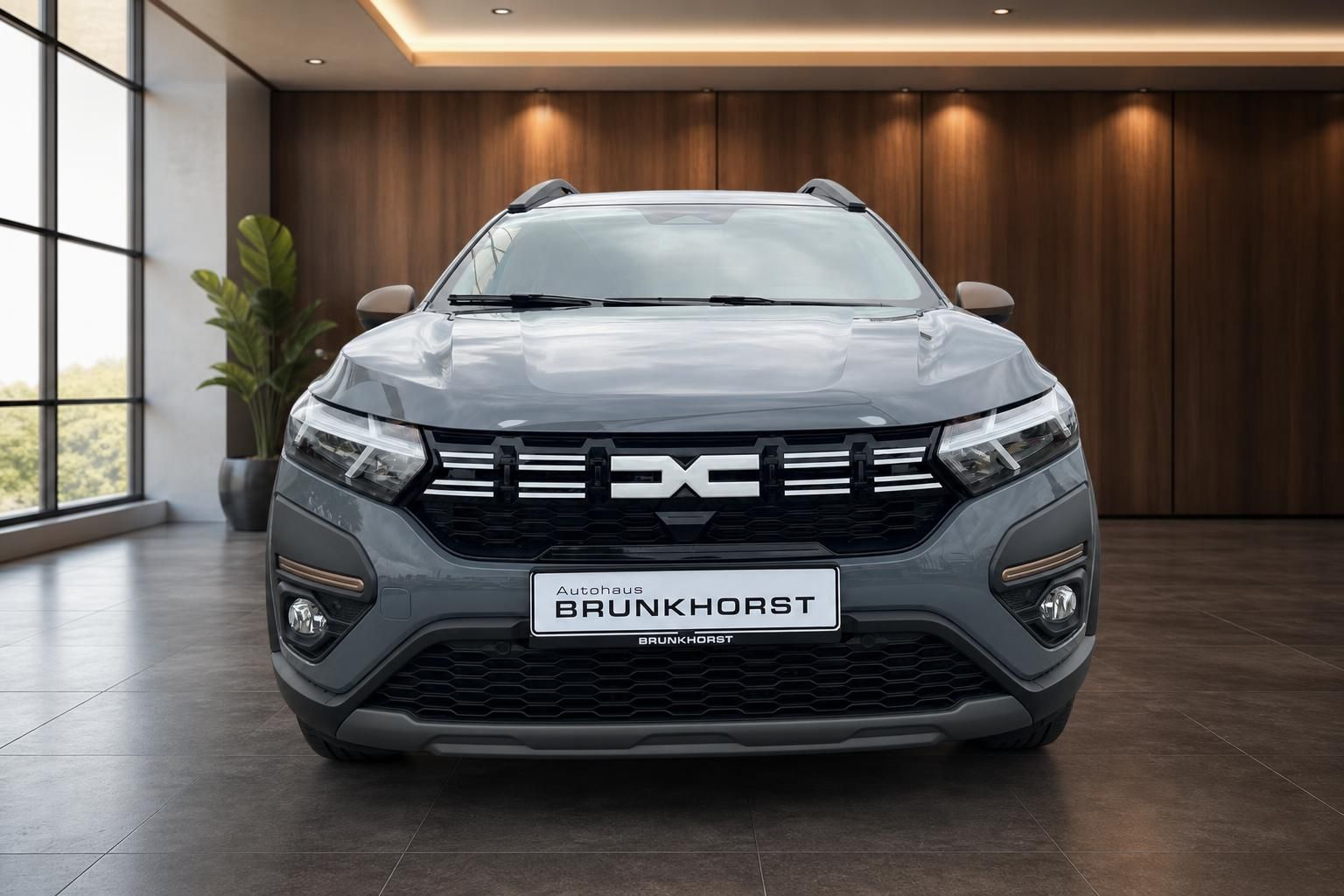 Dacia Jogger Hybrid grau - Frontansicht mit Kühlergrill und LED-Scheinwerfern im Autohaus
