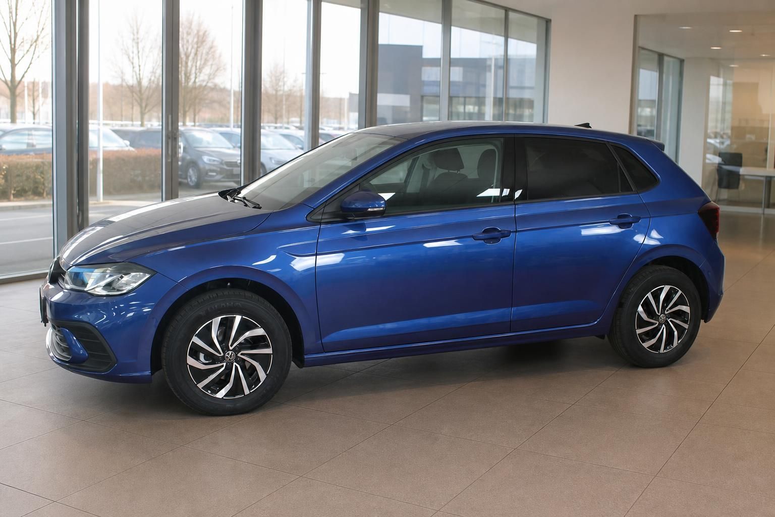 VW Polo blau Seitenansicht im Autohaus vor grosser Fensterfront