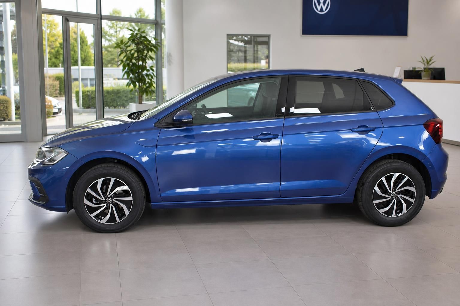 VW Polo blau Seitenansicht im Verkaufsraum mit VW Logo
