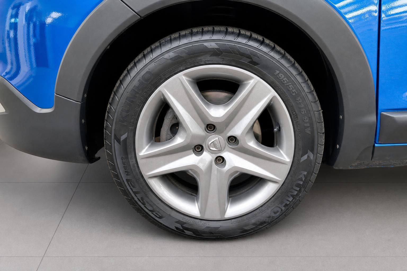 Detailansicht Leichtmetallfelge und Reifen eines blauen Dacia