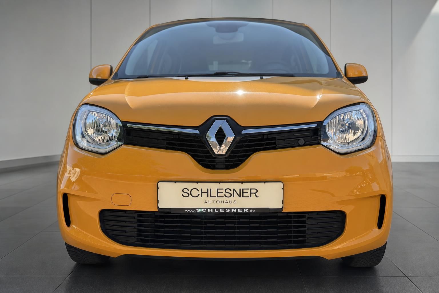Renault Twingo gelb, Frontansicht mit Kuehlergrill im Showroom