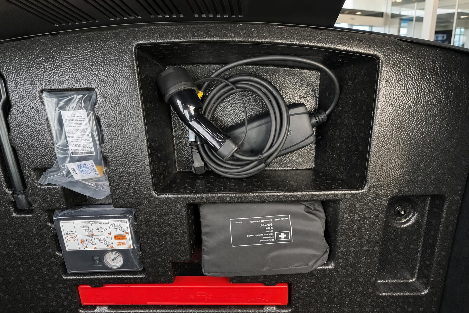 Kofferraum mit Ladekabel, Erste-Hilfe-Set und Kompressor für Elektrofahrzeug