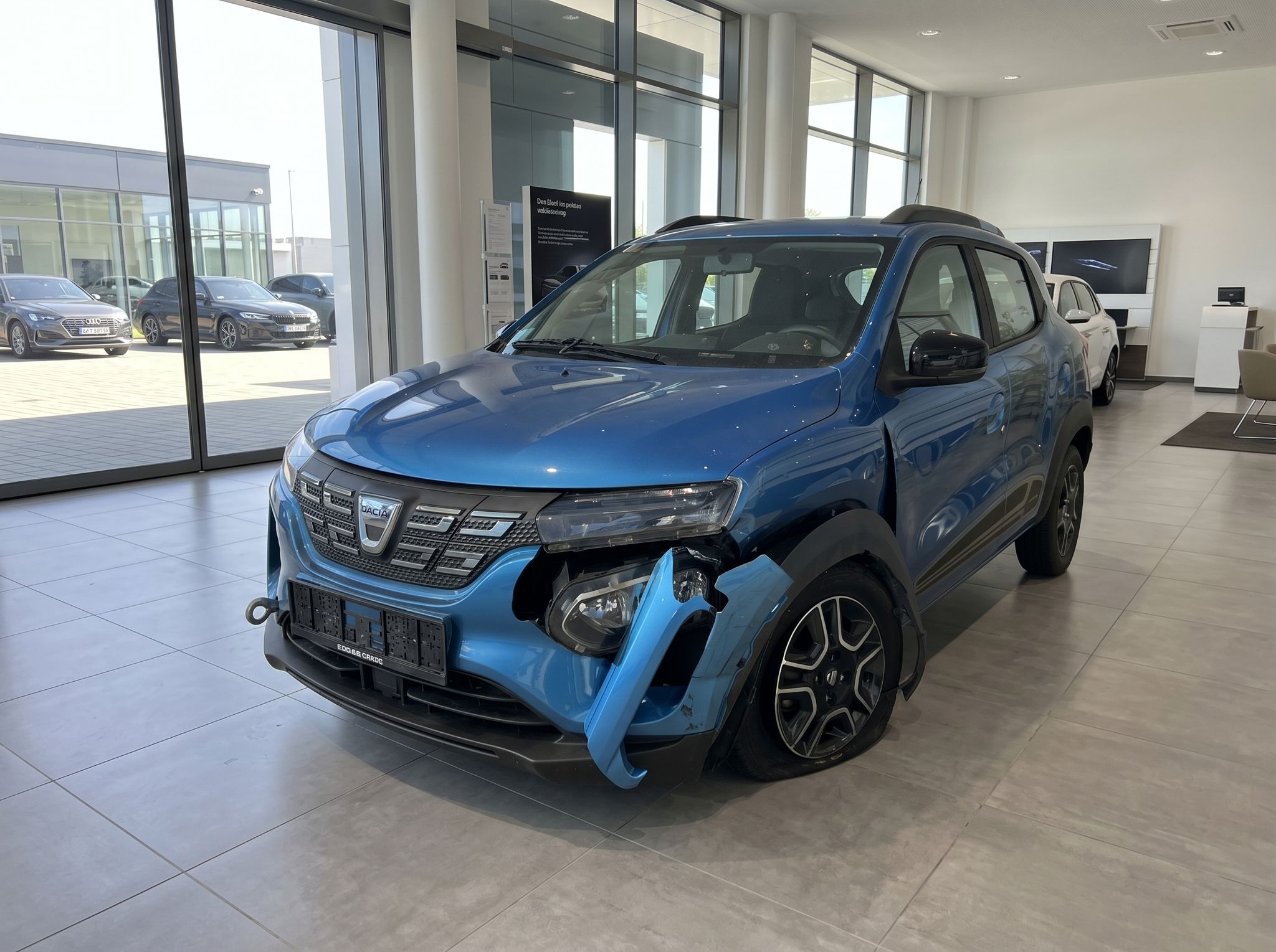 Dacia Spring Elektro-SUV blau im Autohaus-Showroom - Seitenansicht vorne links