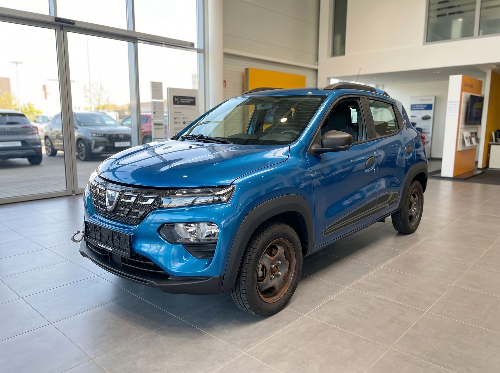 Dacia Spring Elektro-SUV blau - Dreiviertel-Frontansicht im modernen Autohaus