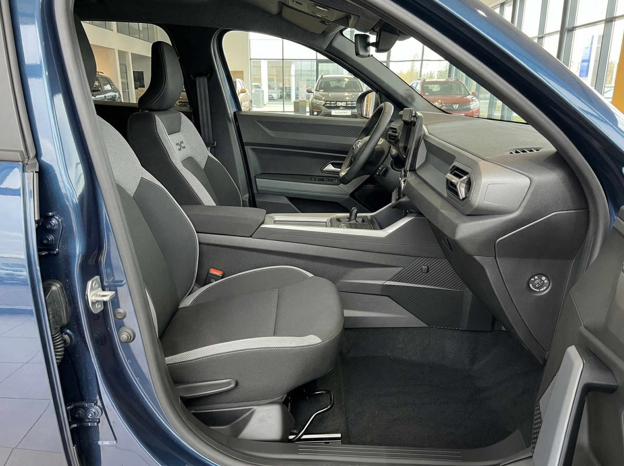 PKW Innenraum Beifahrerseite mit Sitzen, Armaturenbrett und offener Tür