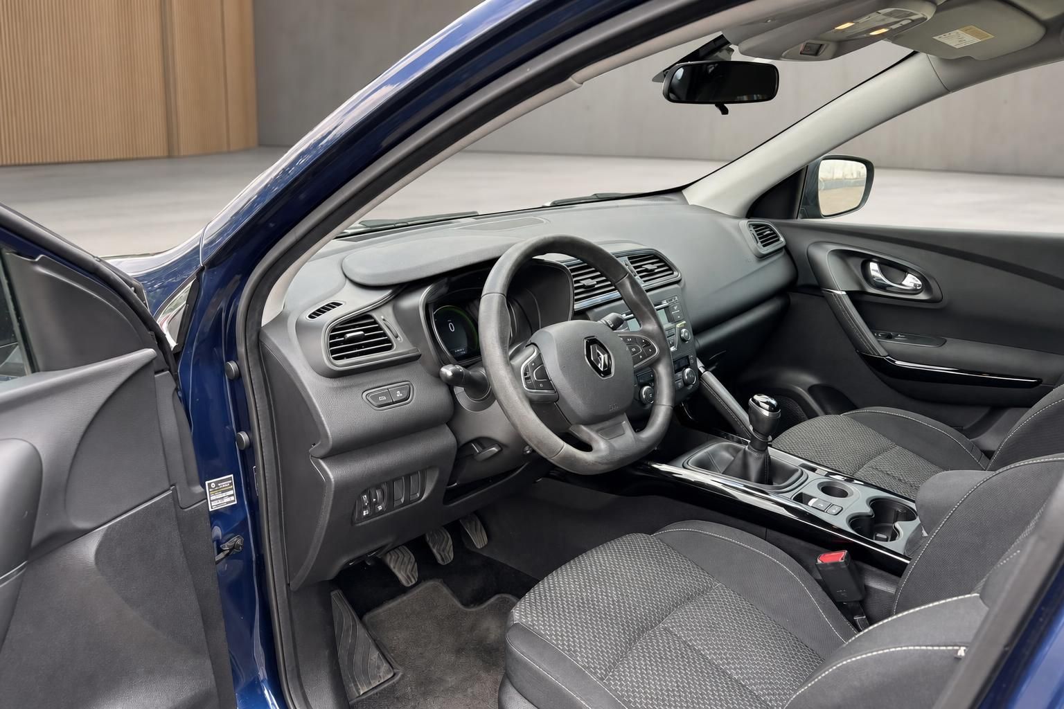Fahrzeuginnenraum mit schwarzem Armaturenbrett, Lenkrad und Sitzen in modernem Design