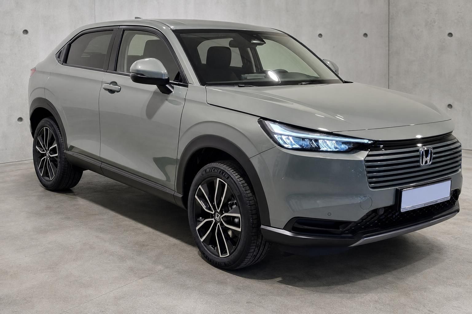 Honda HR-V in Grau, Frontansicht schräg, moderner SUV vor Betonwand
