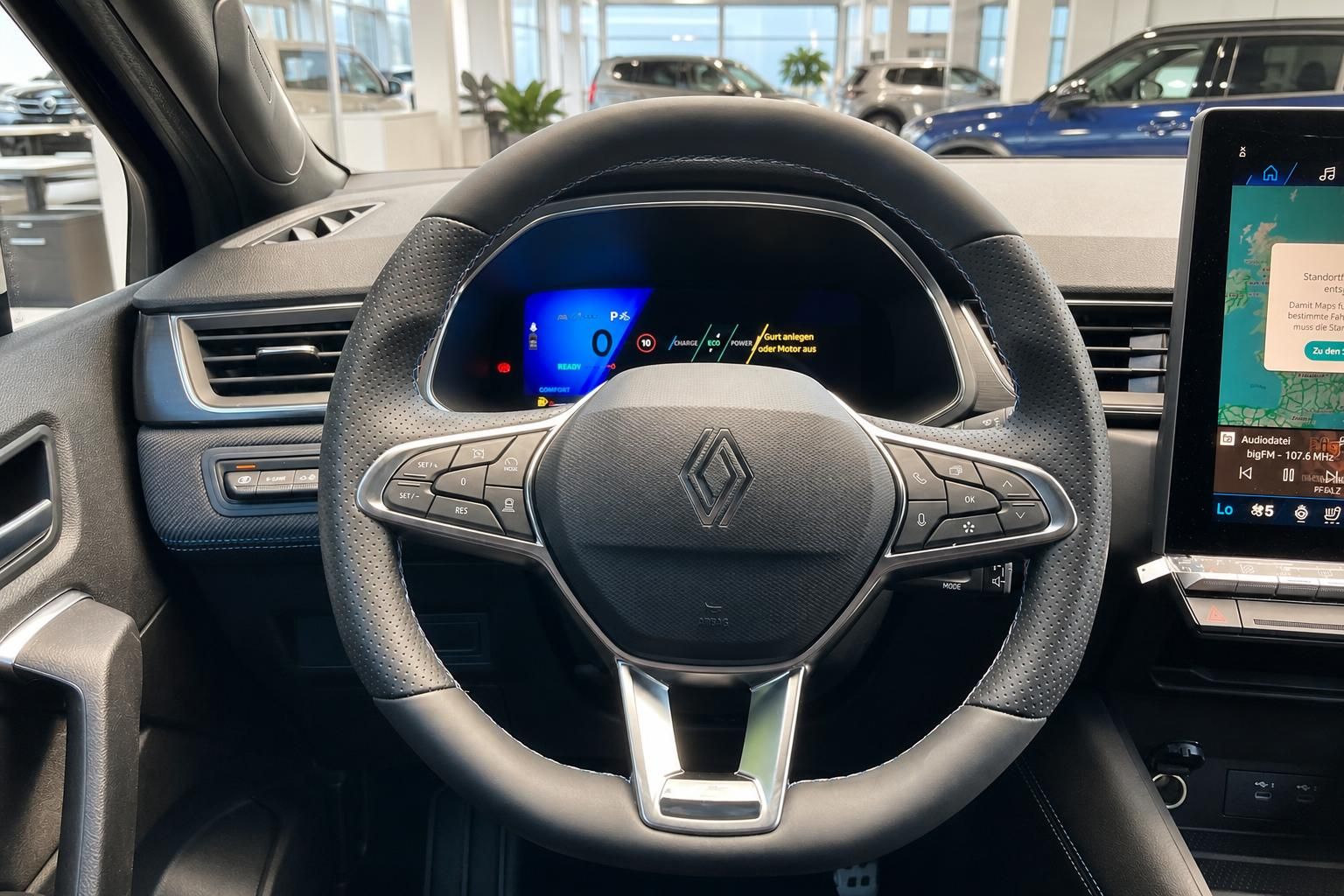 Renault Lenkrad mit Multifunktionstasten und digitalem Cockpit-Display im Hintergrund