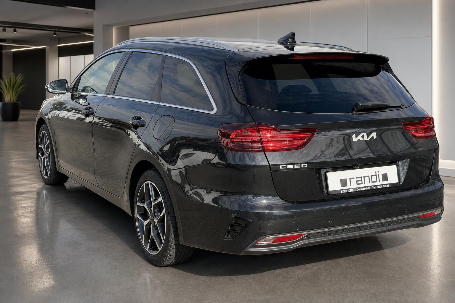 Kia Ceed SW Kombi schwarz Dreiviertel-Heckansicht im Showroom mit LED-Rücklichtern