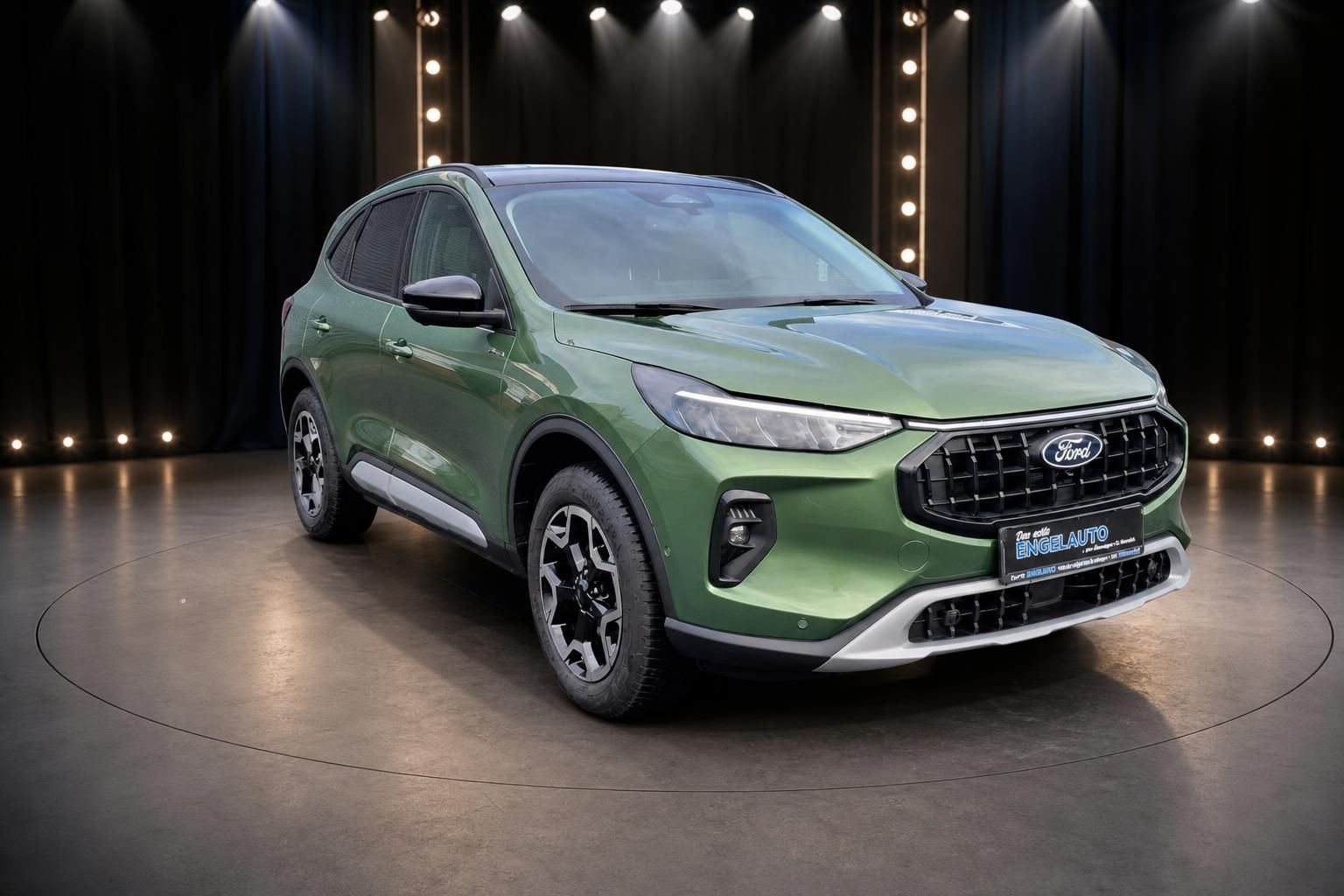 Grüner Ford Kuga SUV von vorne links im Showroom - modernes Design mit LED-Scheinwerfern