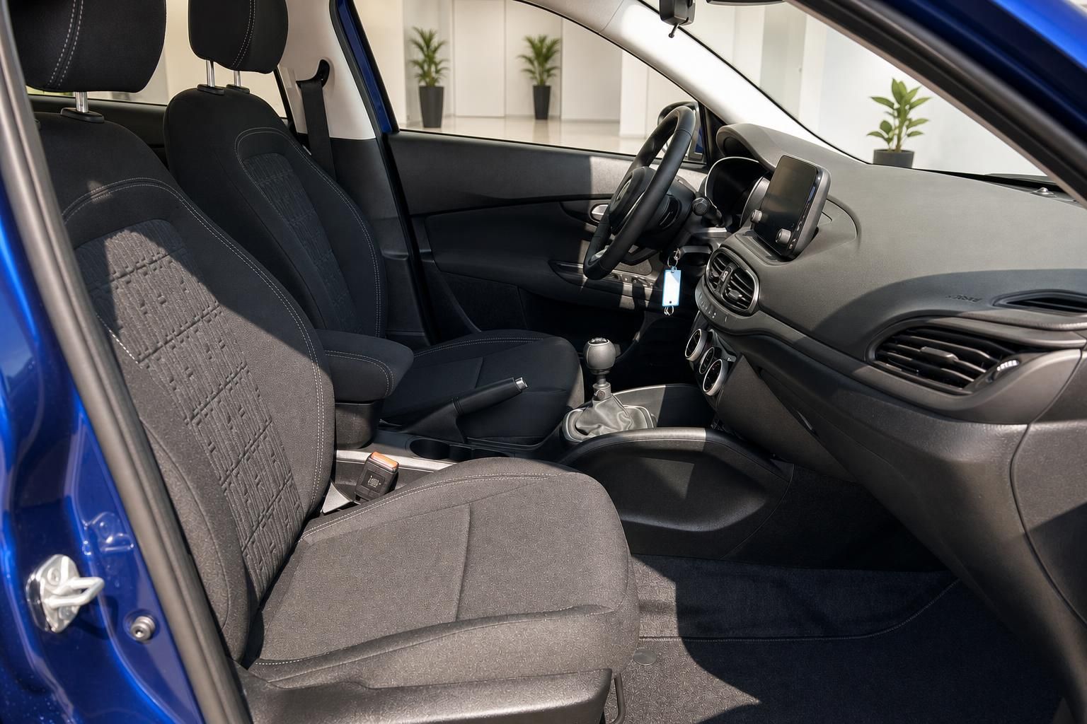 Fiat Tipo Innenraum Vordersitze mit schwarzem Stoffbezug, Lenkrad und Touchscreen-Navi