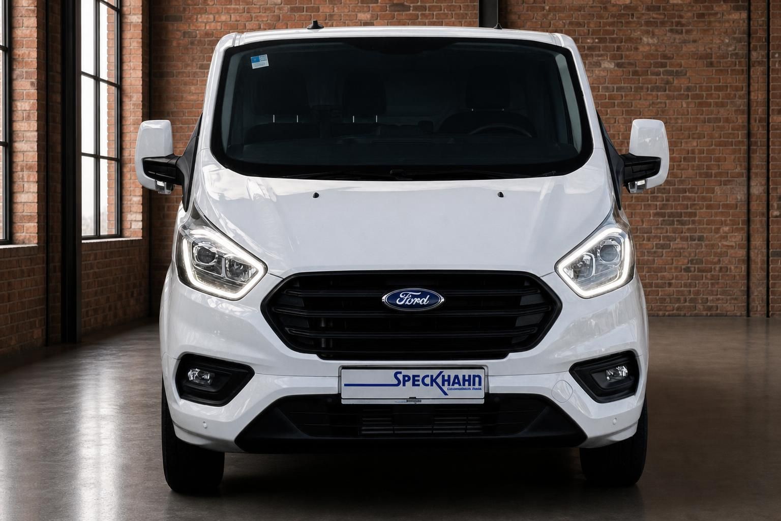 Ford Transit Custom weiss Frontansicht in Ausstellungsraum mit Speckhahn Kennzeichenhalter