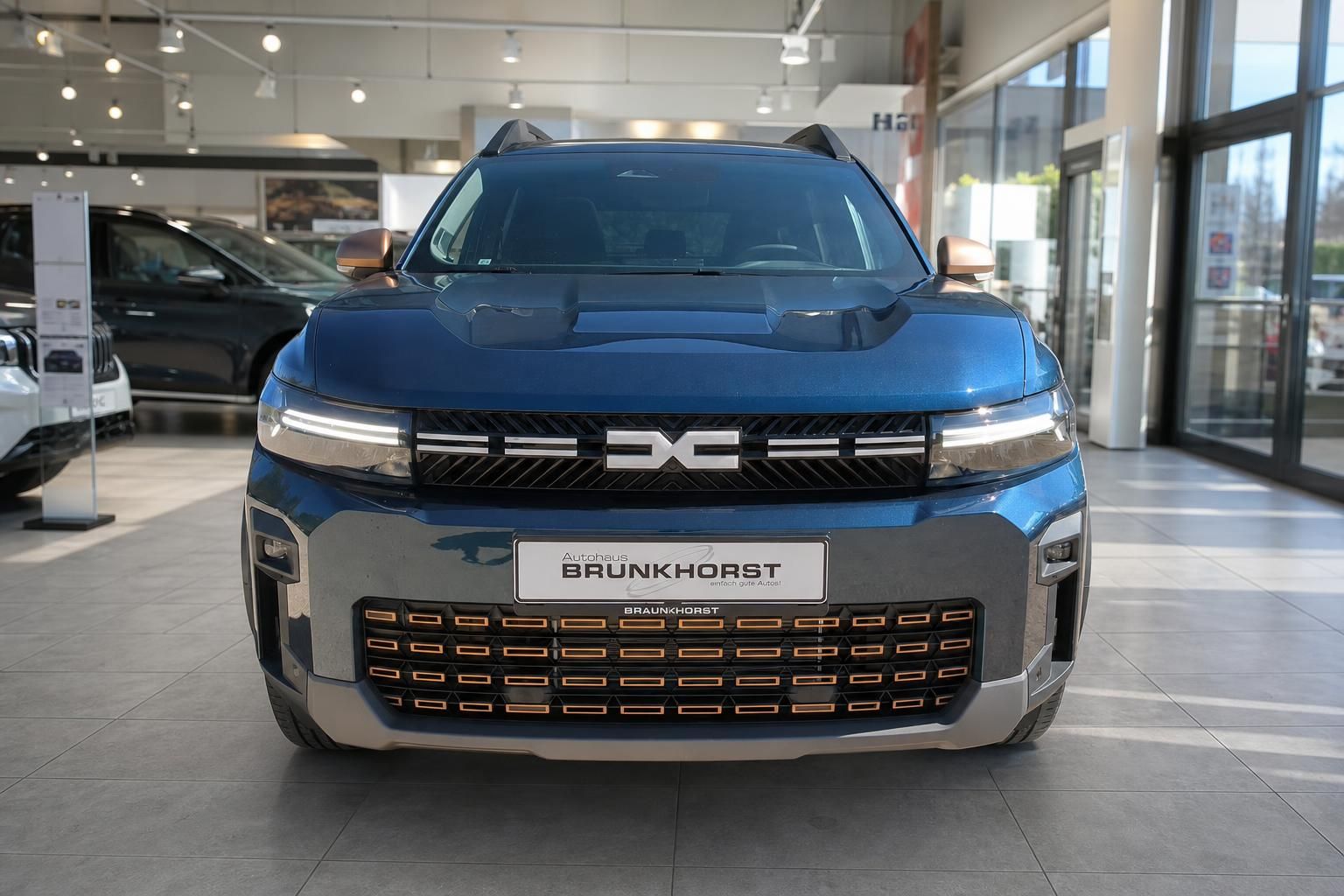Dacia SUV Frontansicht in Blau mit charakteristischem Kühlergrill und LED-Tagfahrlicht