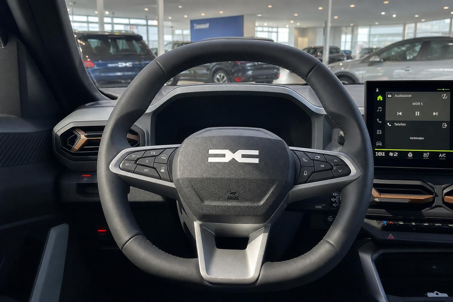 Fahrzeug Lenkrad mit Markenlogo und Touchscreen im Cockpit Bereich