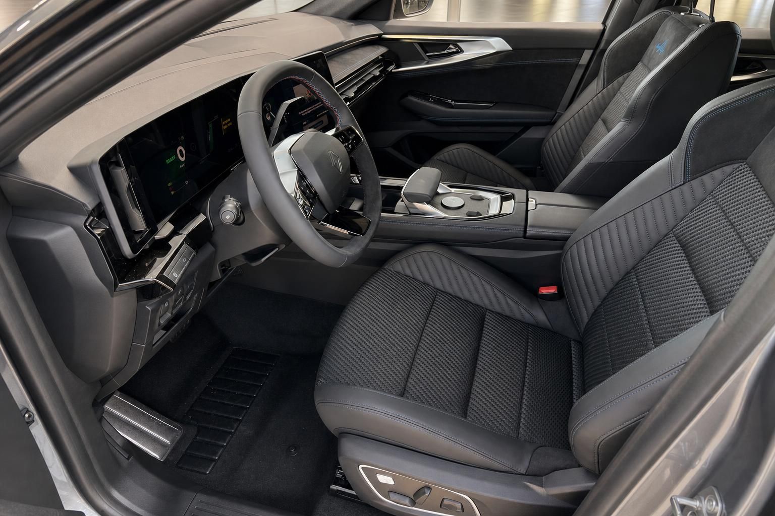 Fahrzeuginnenraum mit schwarzen Sportsitzen und modernem Cockpit-Display