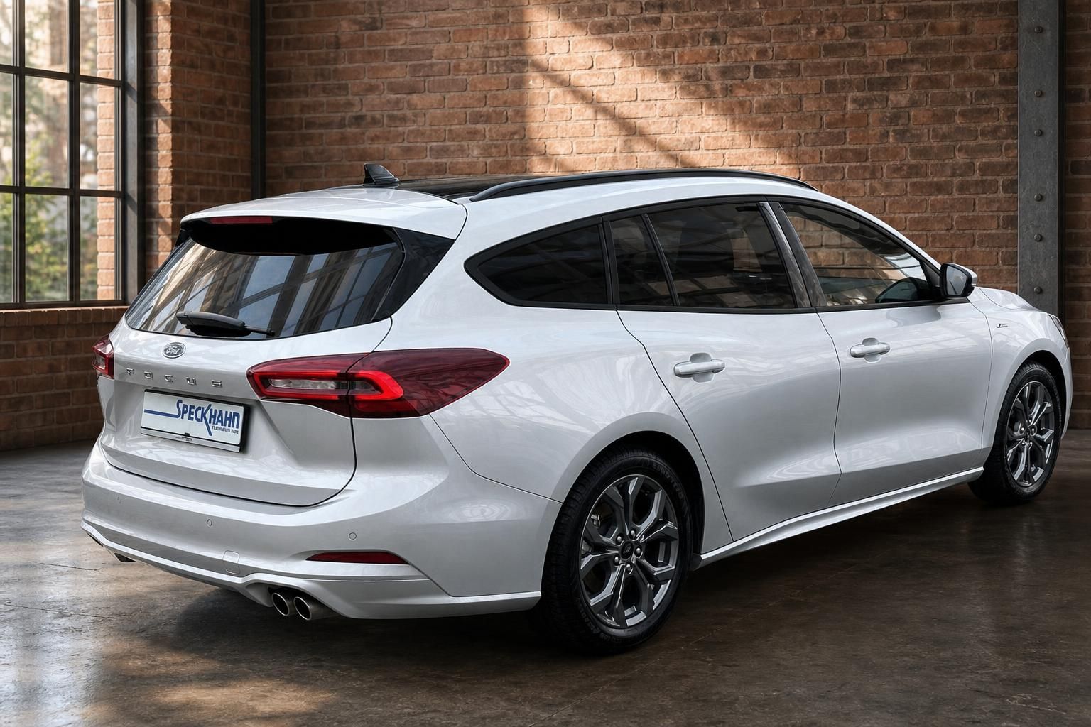 Ford Focus Turnier weiss Heckansicht schraeg mit Alufelgen in Industriehalle