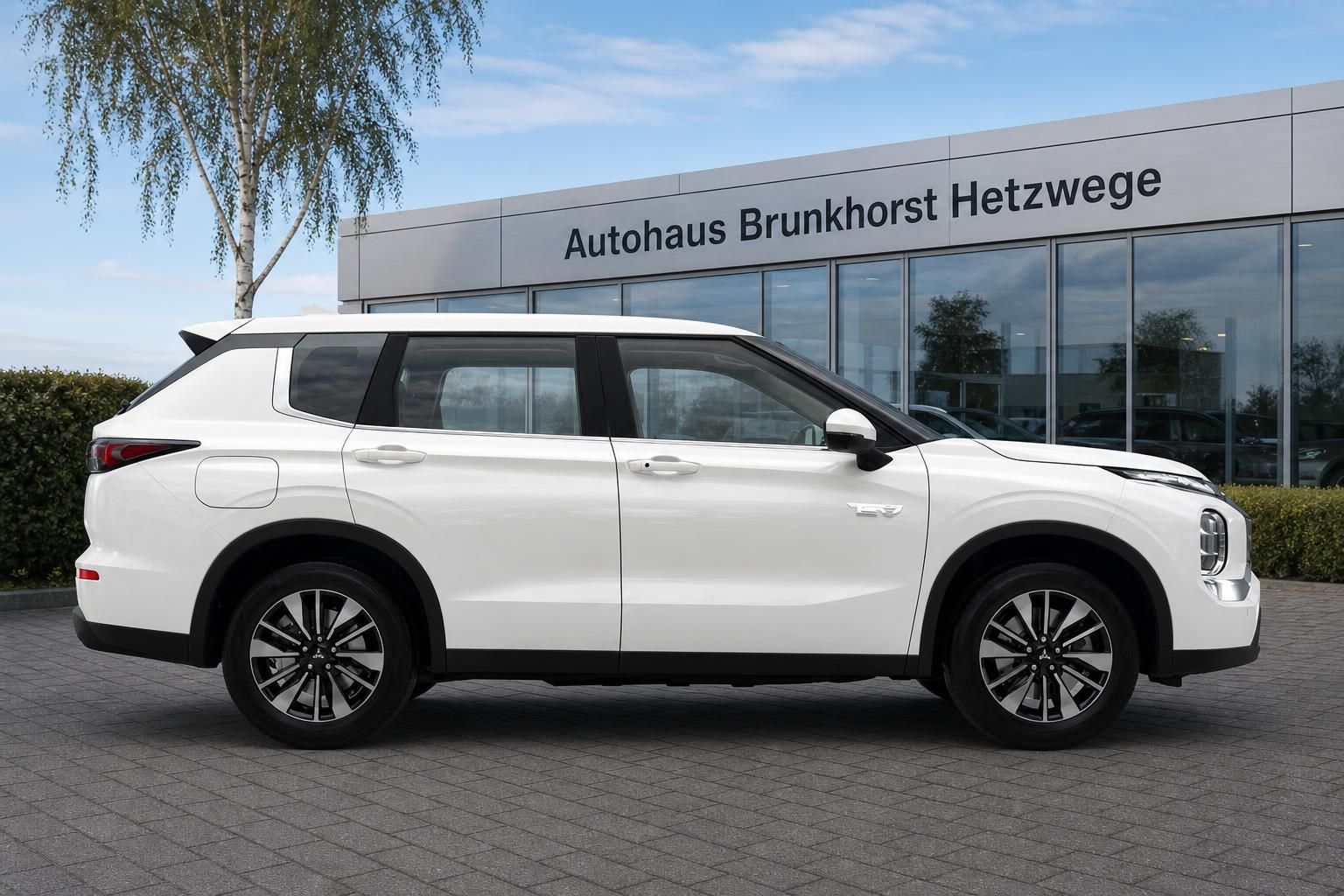 Mitsubishi Outlander in Weiß Seitenansicht vor Autohaus Brunkhorst Hetzwege