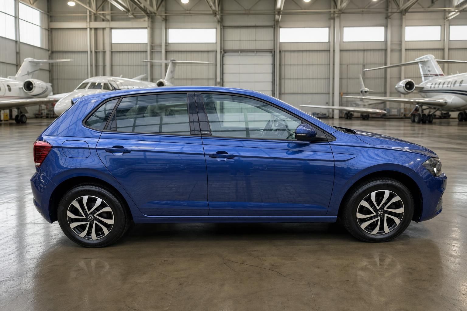 Volkswagen Polo blau metallic - Seitenprofil des kompakten Stadtautos in Fahrzeughalle
