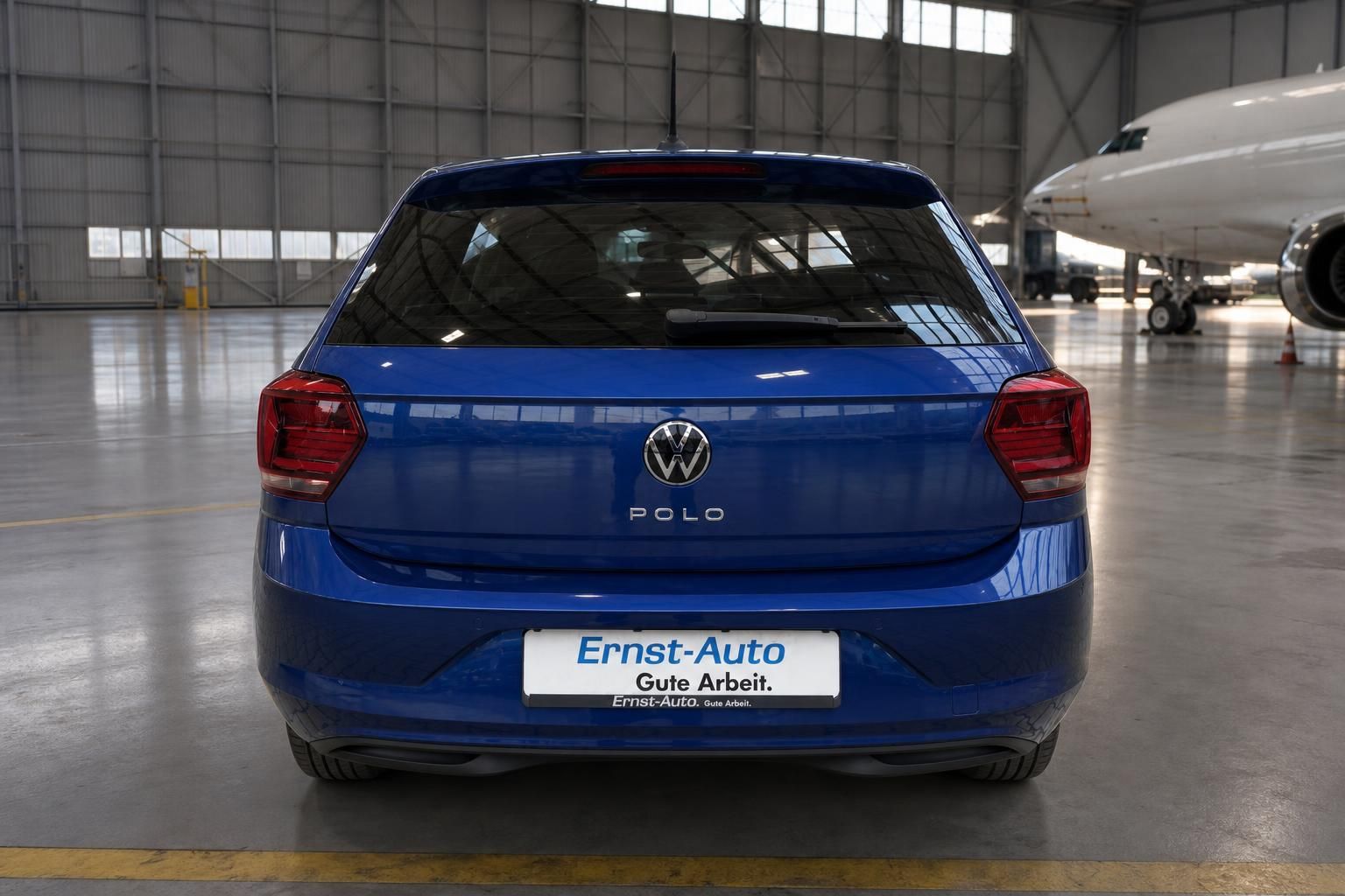 Volkswagen Polo in blau - Heckansicht des kompakten Kleinwagens in einer Fahrzeughalle