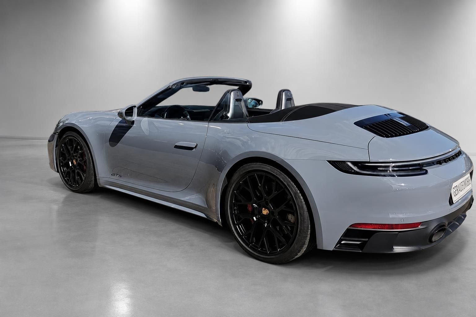 Porsche 911 GTS Cabrio in Nardograu, Heckansicht mit schwarzen Felgen