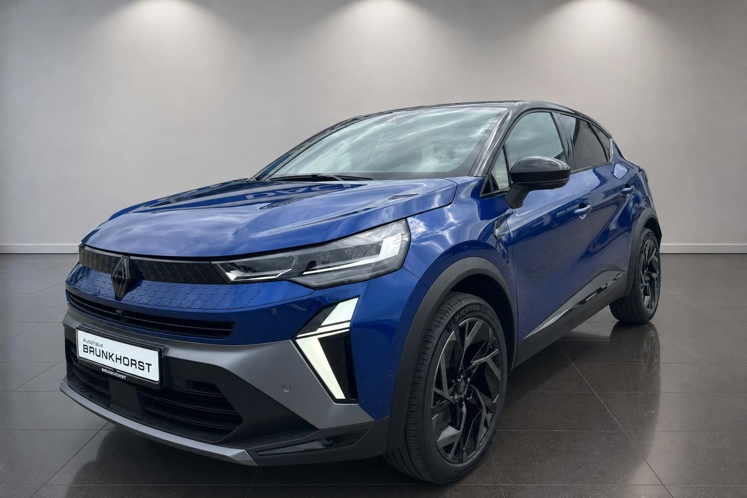 Blauer Renault Captur SUV Seitenansicht mit schwarzen Akzenten und Leichtmetallfelgen im Showroom