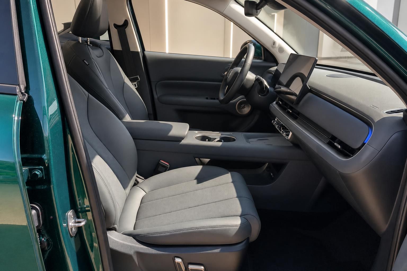 Fahrzeuginnenraum mit Vordersitzen, Lenkrad und Infotainment-Display