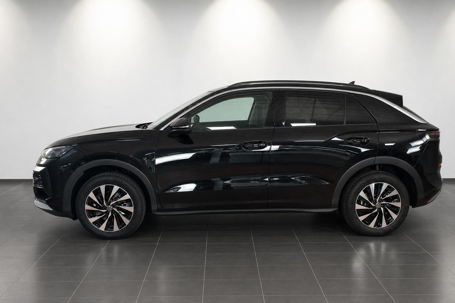 VW SUV schwarz Seitenprofil vor weisser Wand im Showroom