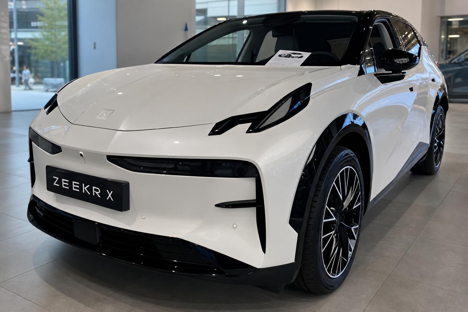 Zeekr X in Weiß, Frontansicht mit Alufelgen im Showroom