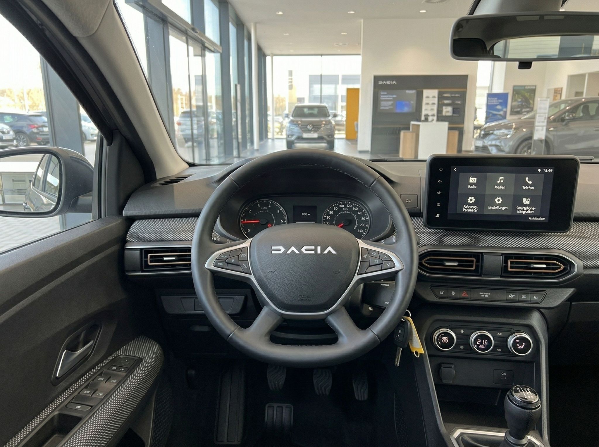 Dacia Cockpit-Ansicht mit Lenkrad, Instrumententafel und Infotainment-System im Autohaus
