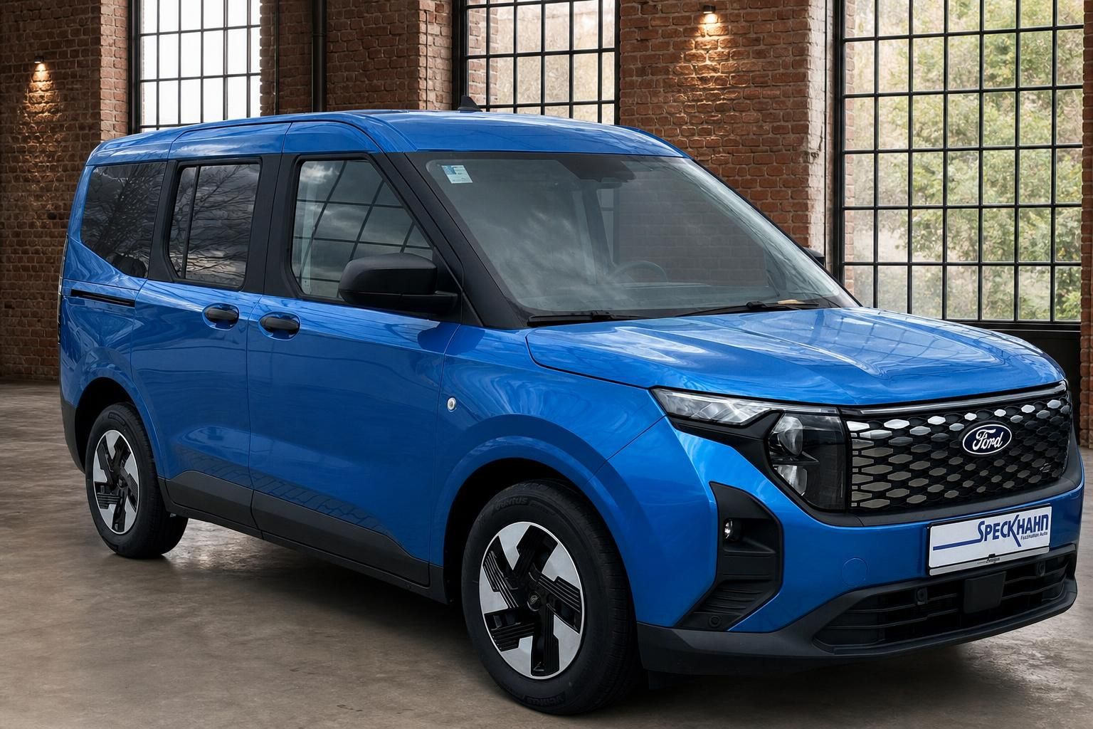 Ford Tourneo blau in Frontansicht schraeg vor Backsteinwand